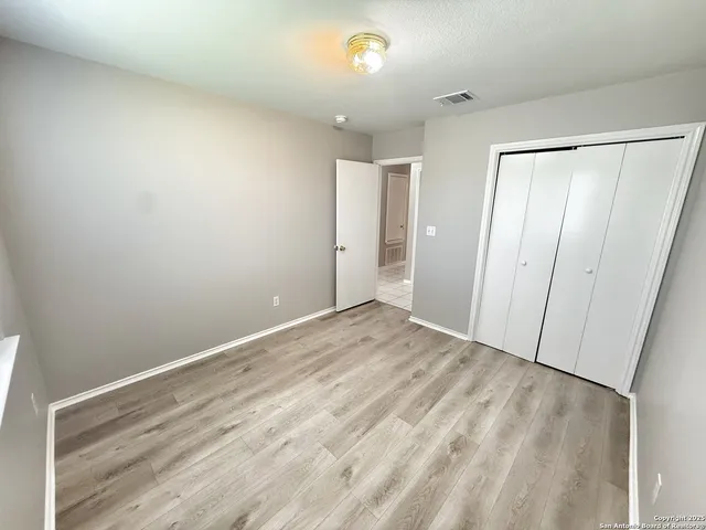 a view of empty room with wooden floor