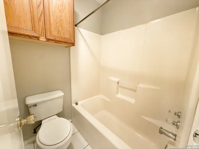 a white toilet sitting next to a bath tub