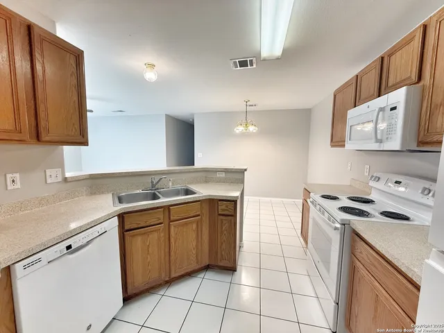 a kitchen with a stove sink and cabinets