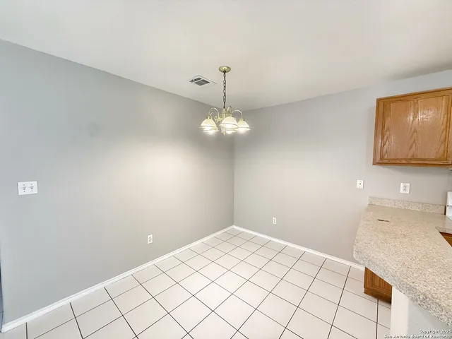 a view of a kitchen with a sink cabinetry and chandelier