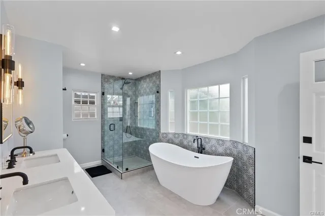 a bathroom with a tub sink and mirror