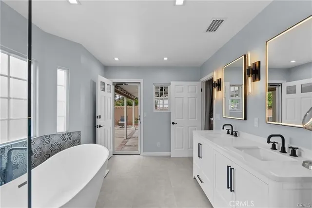 a bathroom with a tub sink and mirror