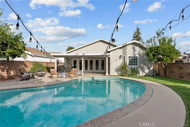 a view of a house with swimming pool and sitting area