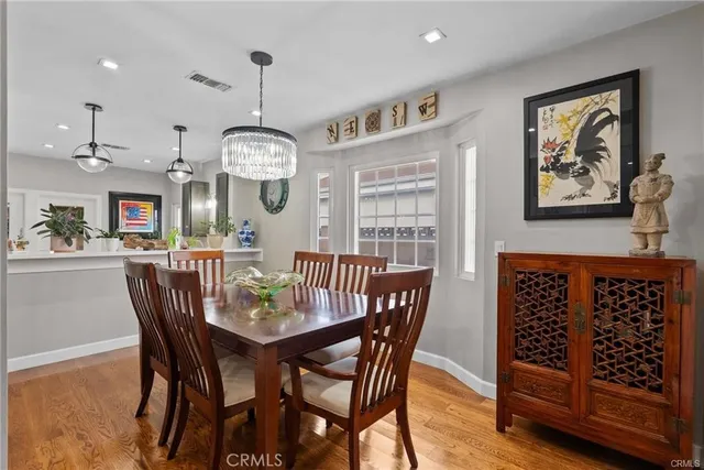 a view of a dining room and livingroom with furniture wooden floor a chandelier
