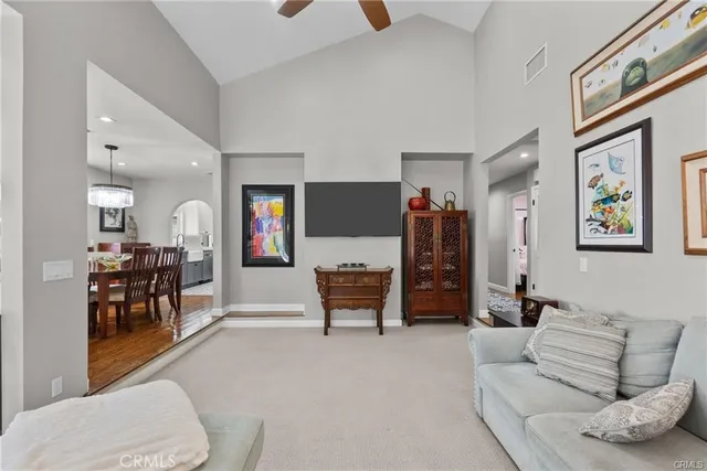 a living room with furniture and a dining table with wooden floor