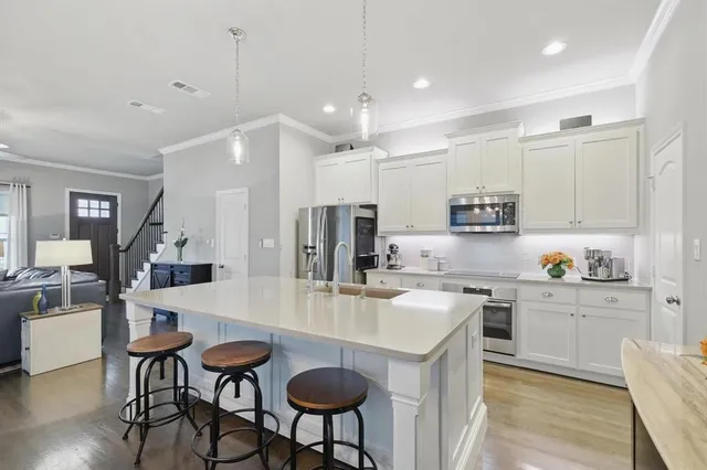 a kitchen with stainless steel appliances kitchen island granite countertop a sink and cabinets