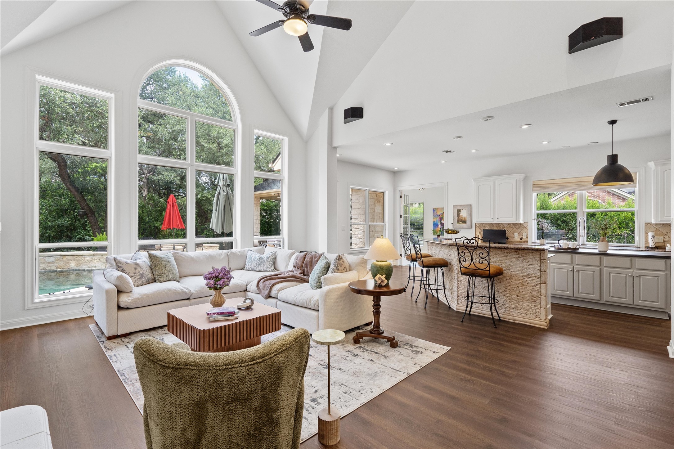 4313 Rio Robles Drive Austin, TX 78746 - Photo 9 of 40 Sun-filled living area featuring vaulted ceilings, rich hardwood flooring, and expansive windows with picturesque views.
