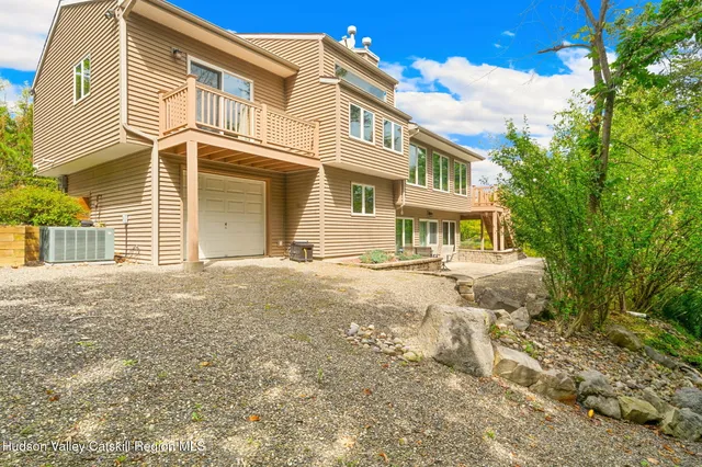 a view of a hallway to a bedroom with wooden floor and windows