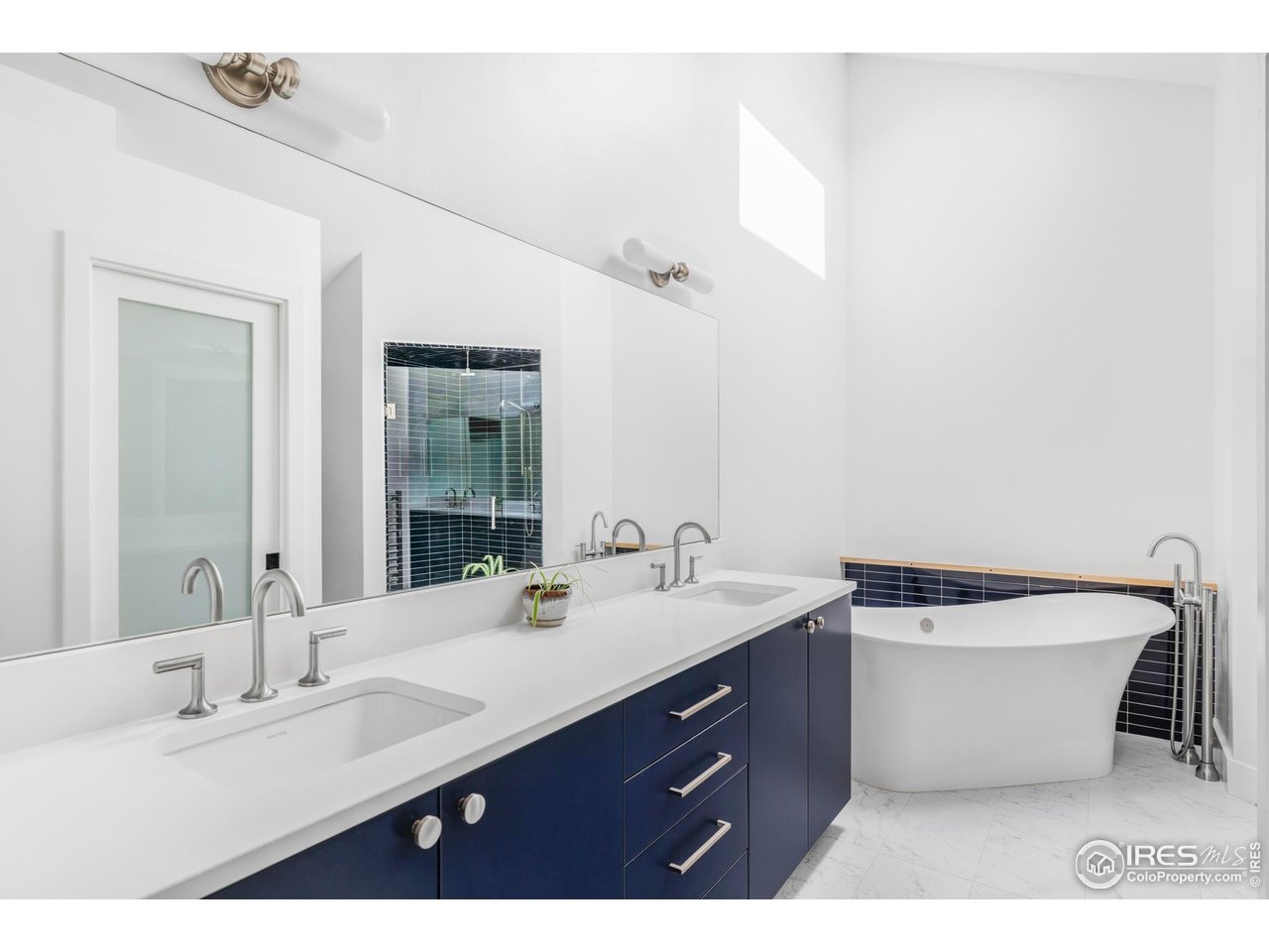 7306 Island Circle Boulder, CO 80301 - Photo 24 of 38 a bathroom with a double vanity sink a mirror and a bathtub