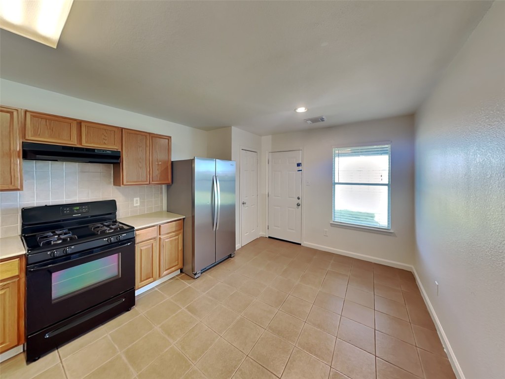 3555 Red Meadows Drive Spring, TX 77386 - Photo 3 of 15 a kitchen with stainless steel appliances granite countertop a stove a refrigerator and a sink