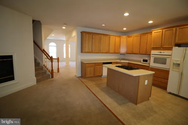 a view of a living room and kitchen with furniture a large window