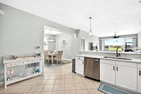 a kitchen with a sink and chairs