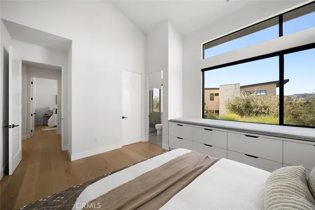 a living room with furniture floor to ceiling window and wooden floor