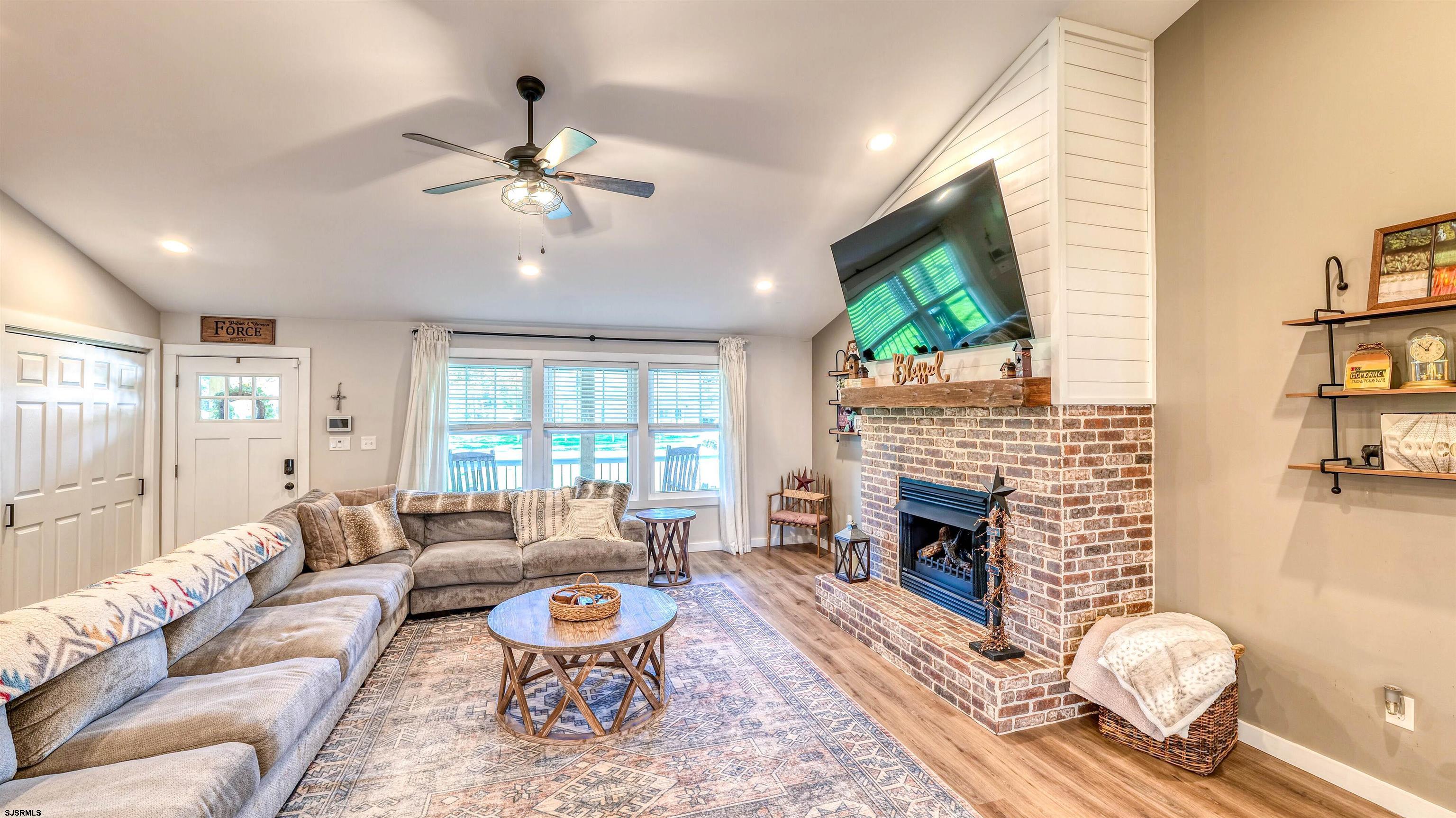 130 Stage Road Little Egg Harbor, NJ 08087 - Photo 11 of 50 a living room with furniture a fireplace and a flat screen tv