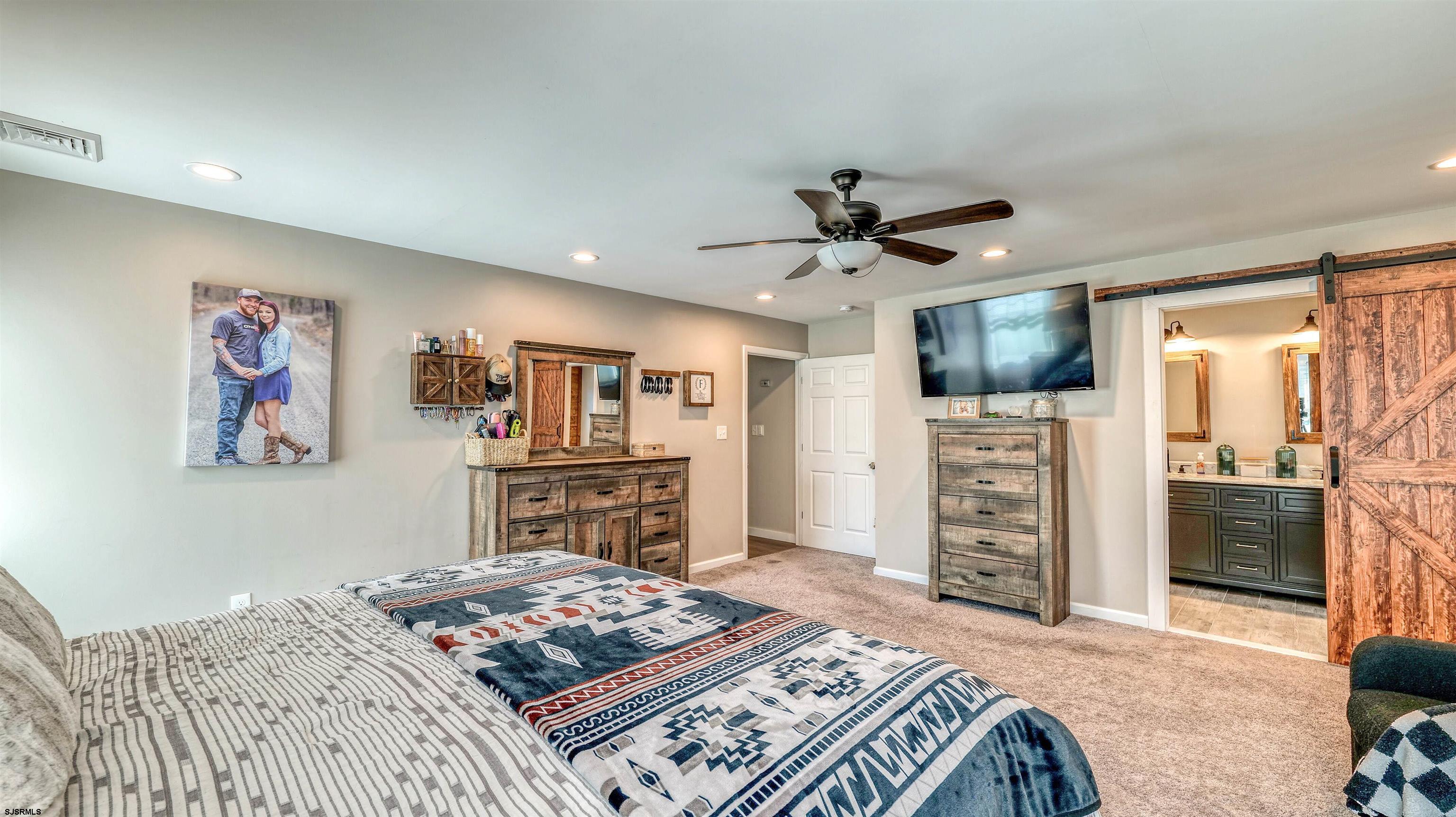 130 Stage Road Little Egg Harbor, NJ 08087 - Photo 30 of 50 a bedroom with a bed dresser and a flat screen tv