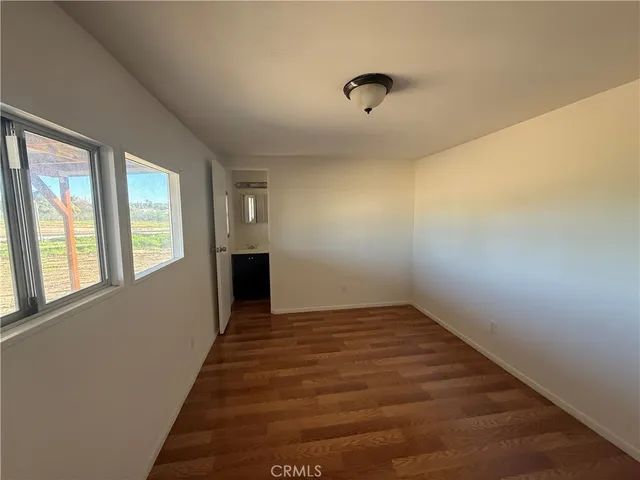 a view of a livingroom with wooden floor and a window