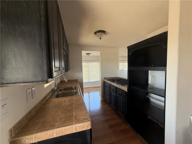 a kitchen with wooden floor and stainless steel appliances