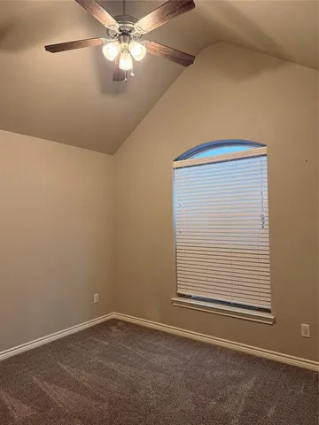 an empty room with a window and ceiling fan