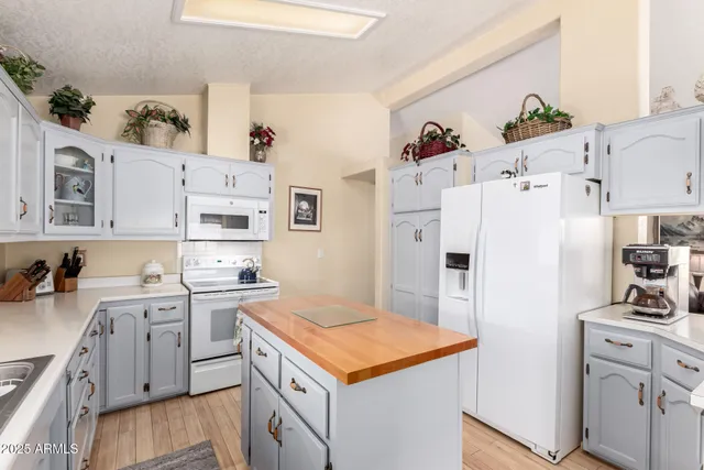 a kitchen with white cabinets and white appliances
