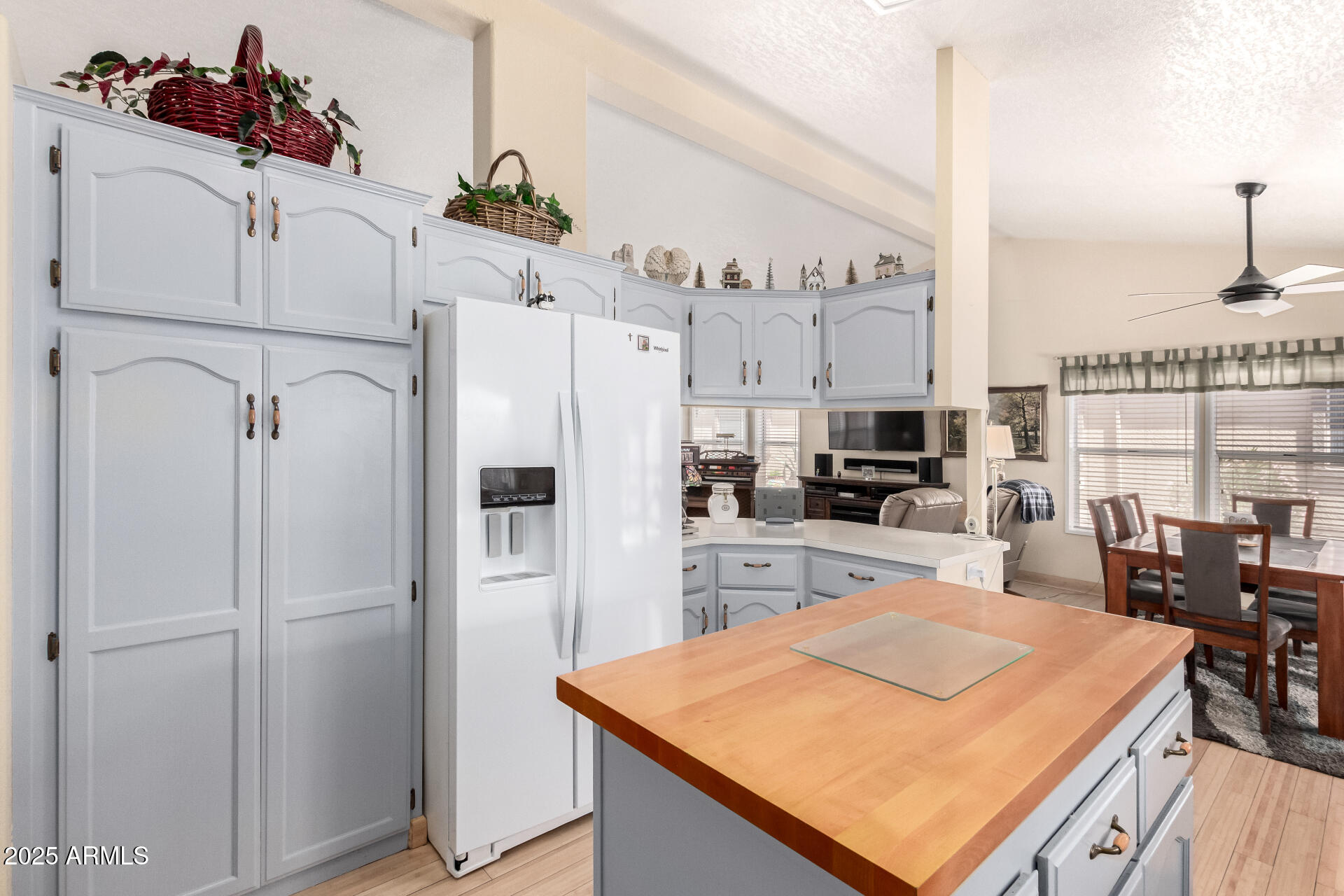 2101 South Meridian Road, Unit 60 Apache Junction, AZ 85120 - Photo 16 of 35 a kitchen with stainless steel appliances kitchen island granite countertop a refrigerator a stove and white cabinets with wooden floor