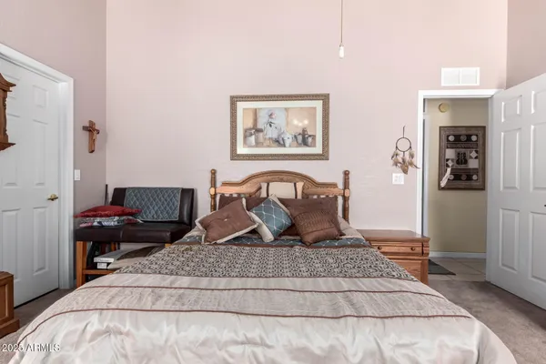 a bedroom with a large bed and a chandelier