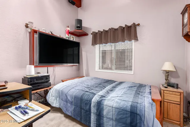 a bedroom with bed and a flat screen tv