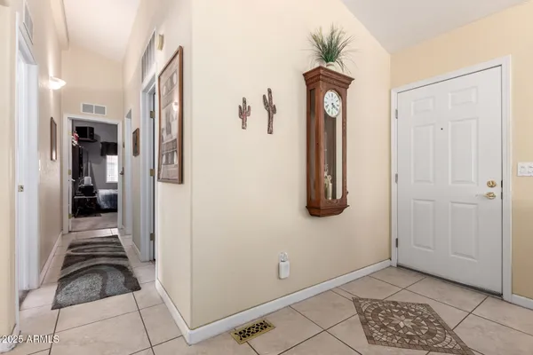 a view of hallway with walk in closet and wooden floor