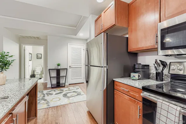 a kitchen with stainless steel appliances granite countertop a refrigerator stove and sink