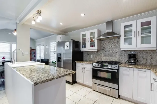 a kitchen with stainless steel appliances granite countertop stove top oven and cabinets