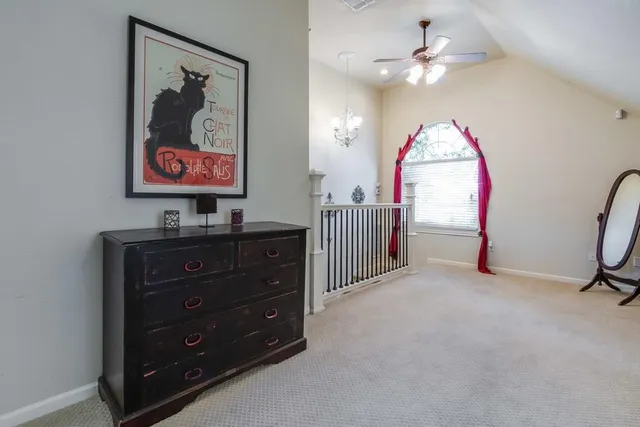 wooden floor with a ceiling fan and a dresser