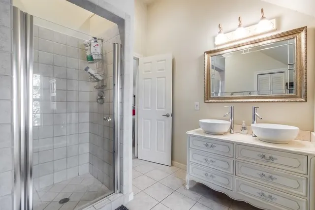 a bathroom with a shower a sink and mirror