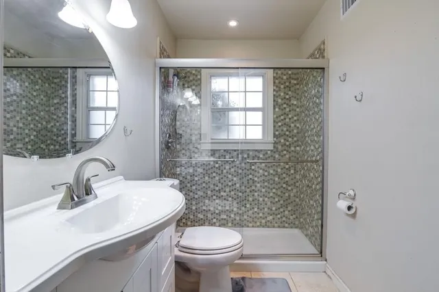 a bathroom with a sink toilet and a mirror