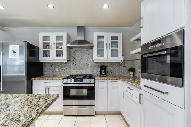 a kitchen with stainless steel appliances granite countertop a stove and a microwave