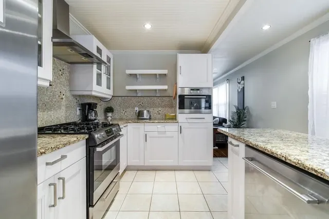 a kitchen with stainless steel appliances granite countertop a stove sink and cabinets