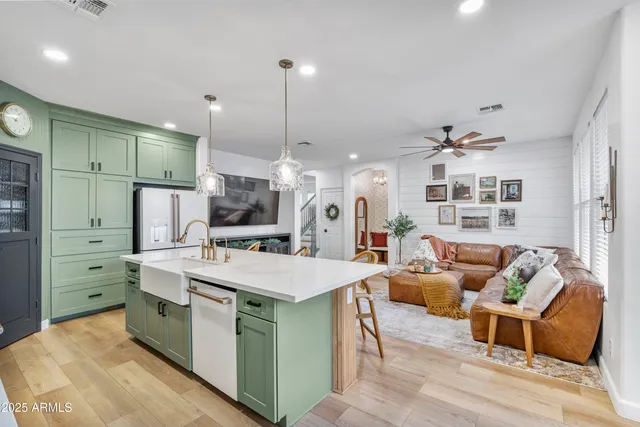 a kitchen with kitchen island granite countertop a sink a counter space appliances and cabinets