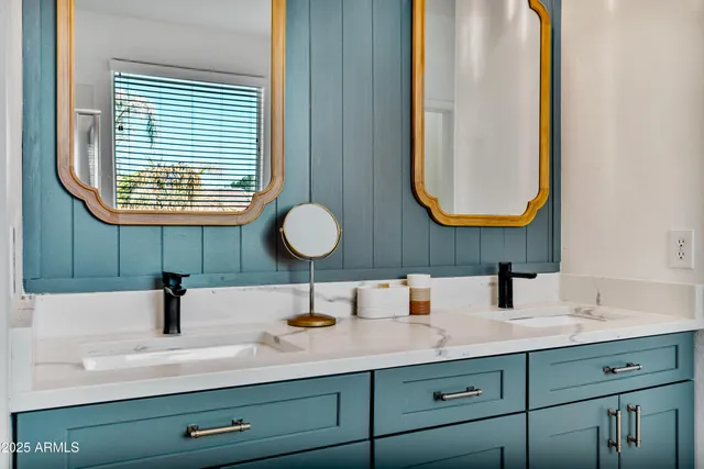 a bathroom with double vanity sinks and a mirror