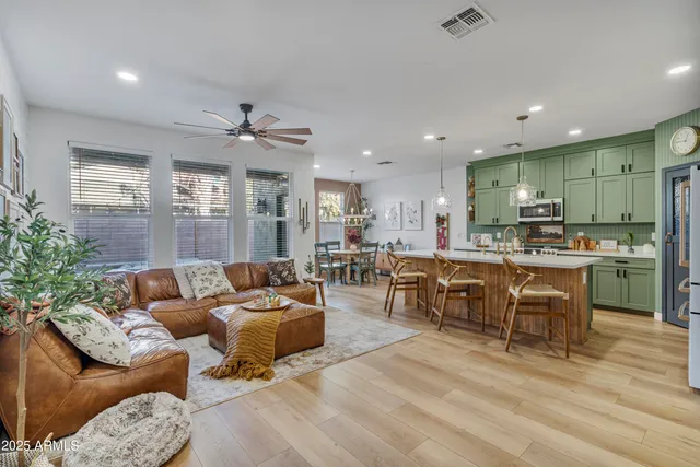 a living room with furniture kitchen view and a large window