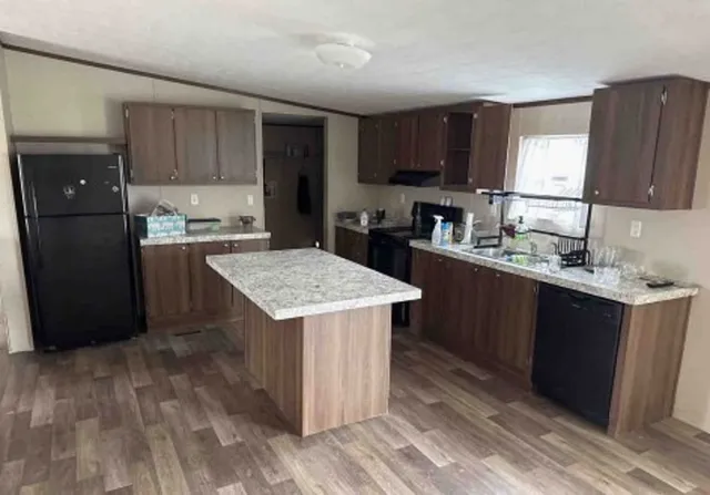 a kitchen with a sink a stove a refrigerator and cabinets