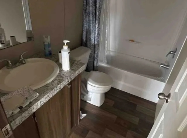 a bathroom with a granite countertop sink toilet and shower