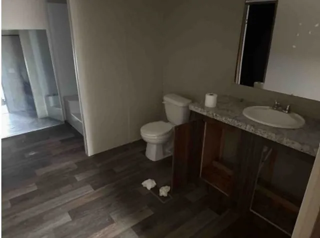 a bathroom with a granite countertop toilet and a sink