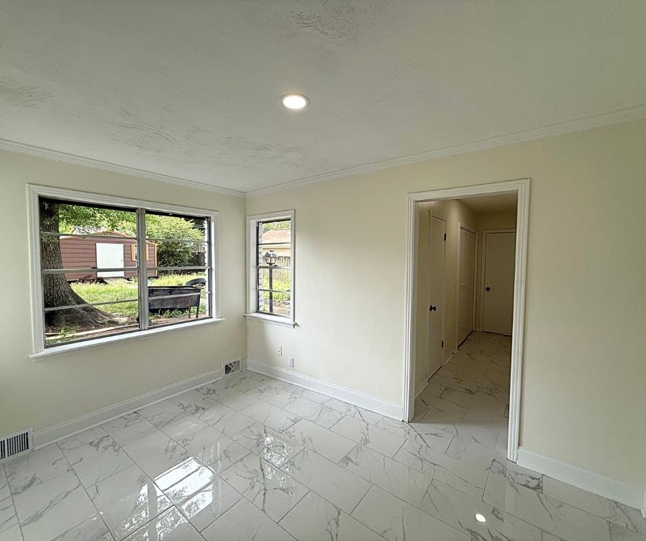 3969 Millbranch Road Memphis, TN 38116 - Photo 11 of 33 Empty room featuring light marble finish flooring, crown molding, recessed lighting, and a textured ceiling