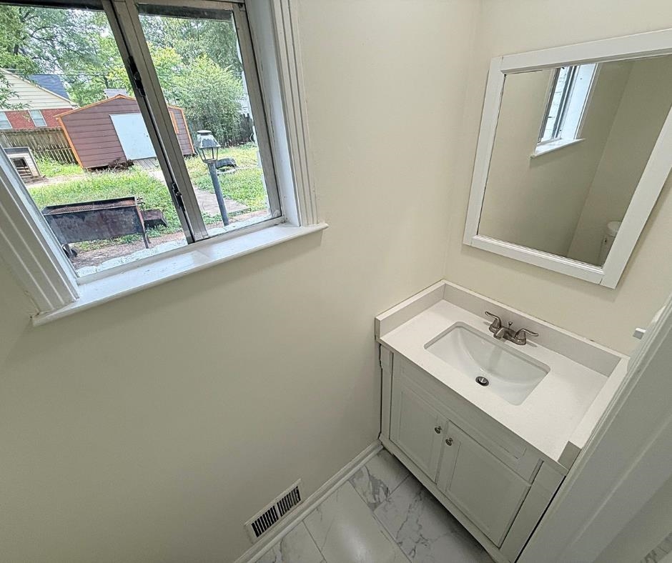 3969 Millbranch Road Memphis, TN 38116 - Photo 14 of 33 Half bathroom featuring vanity and marble look tile flooring
