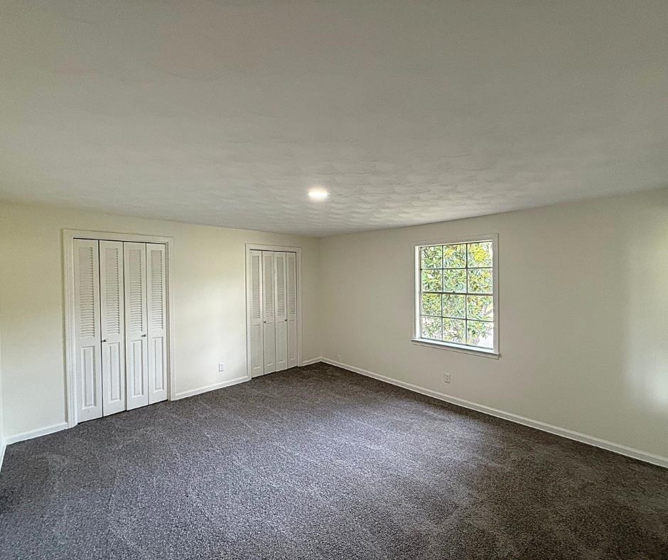 3969 Millbranch Road Memphis, TN 38116 - Photo 20 of 33 Unfurnished bedroom featuring two closets and dark colored carpet