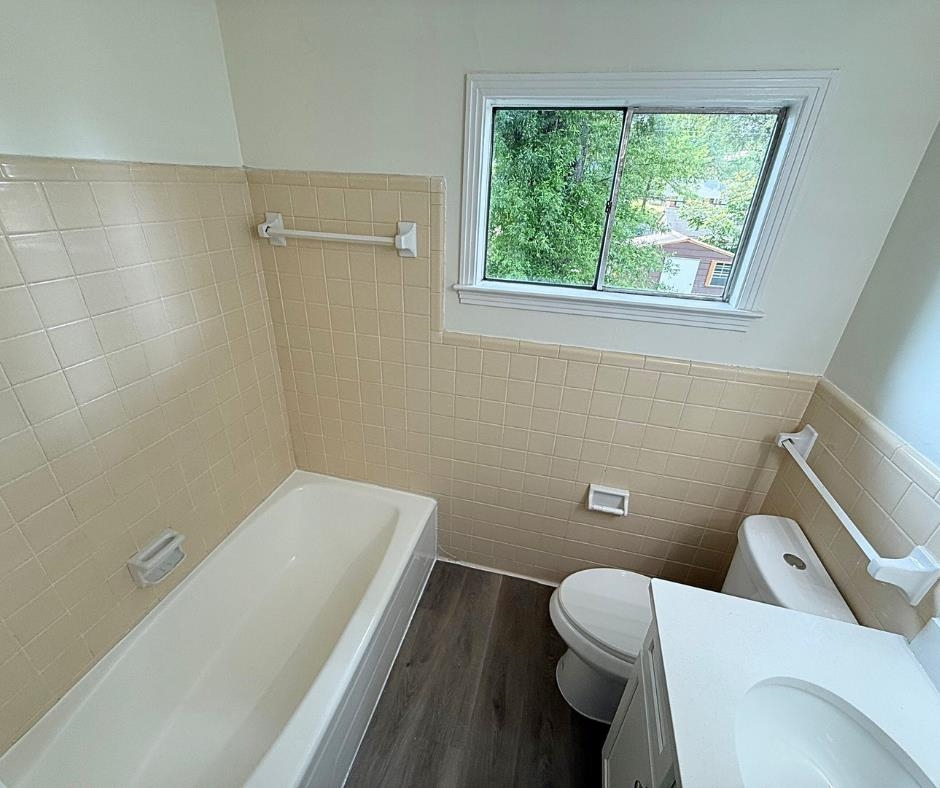 3969 Millbranch Road Memphis, TN 38116 - Photo 22 of 33 Bathroom with tile walls, wood finished floors, a tub, vanity, and wainscoting