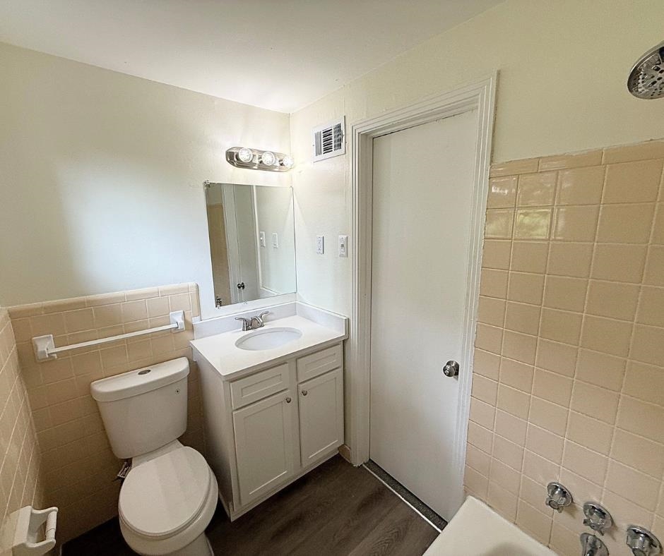 3969 Millbranch Road Memphis, TN 38116 - Photo 23 of 33 Bathroom featuring tile walls, wood finished floors, vanity, and a wainscoted wall