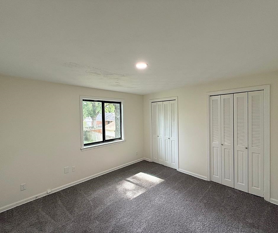 3969 Millbranch Road Memphis, TN 38116 - Photo 24 of 33 Unfurnished bedroom featuring two closets, dark colored carpet, and recessed lighting