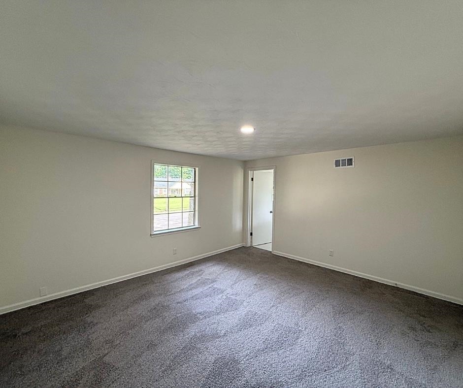 3969 Millbranch Road Memphis, TN 38116 - Photo 26 of 33 Empty room with dark colored carpet and baseboards