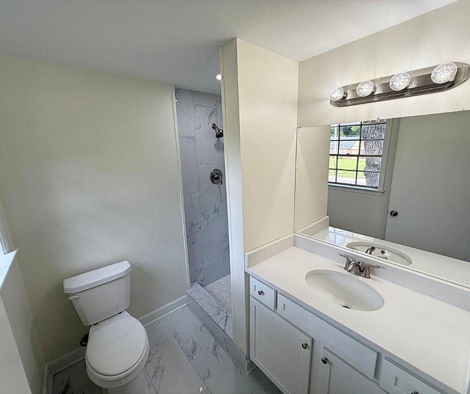 3969 Millbranch Road Memphis, TN 38116 - Photo 28 of 33 Full bathroom featuring marble look tile flooring, vanity, and tiled shower