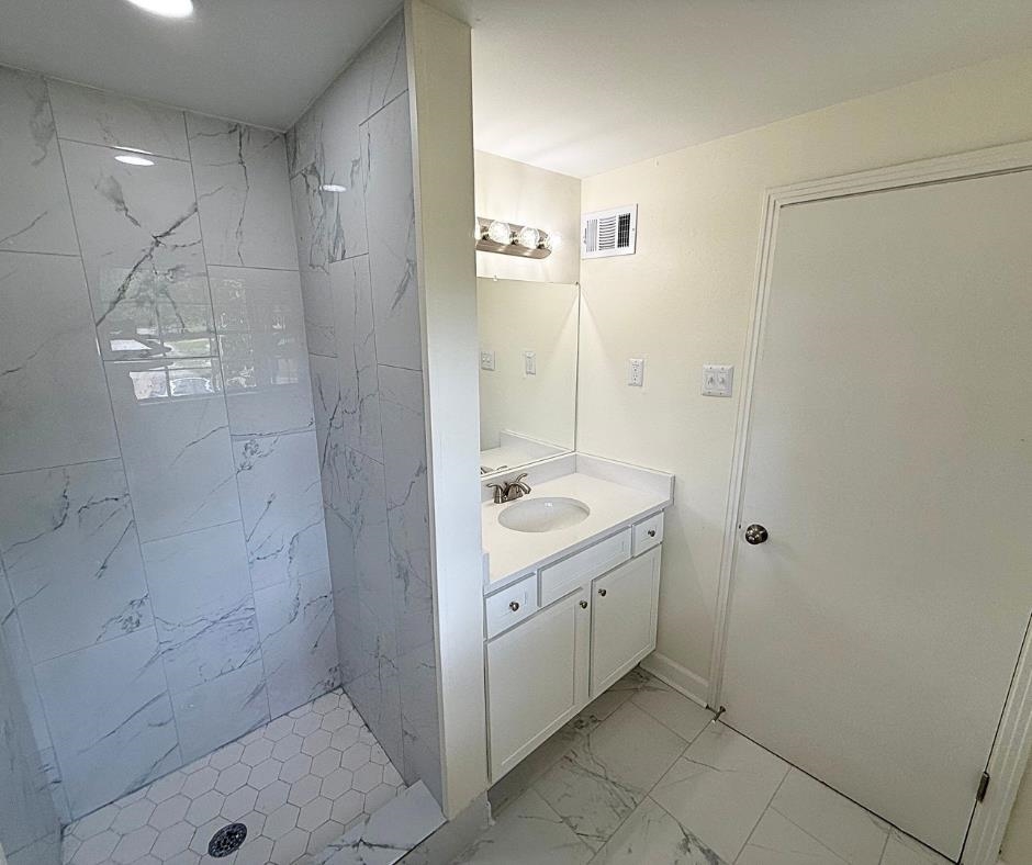 3969 Millbranch Road Memphis, TN 38116 - Photo 29 of 33 Full bathroom featuring marble look tile flooring, vanity, and a stall shower