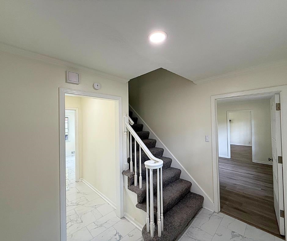 3969 Millbranch Road Memphis, TN 38116 - Photo 3 of 33 Staircase with marble look tiles, ornamental molding, and recessed lighting
